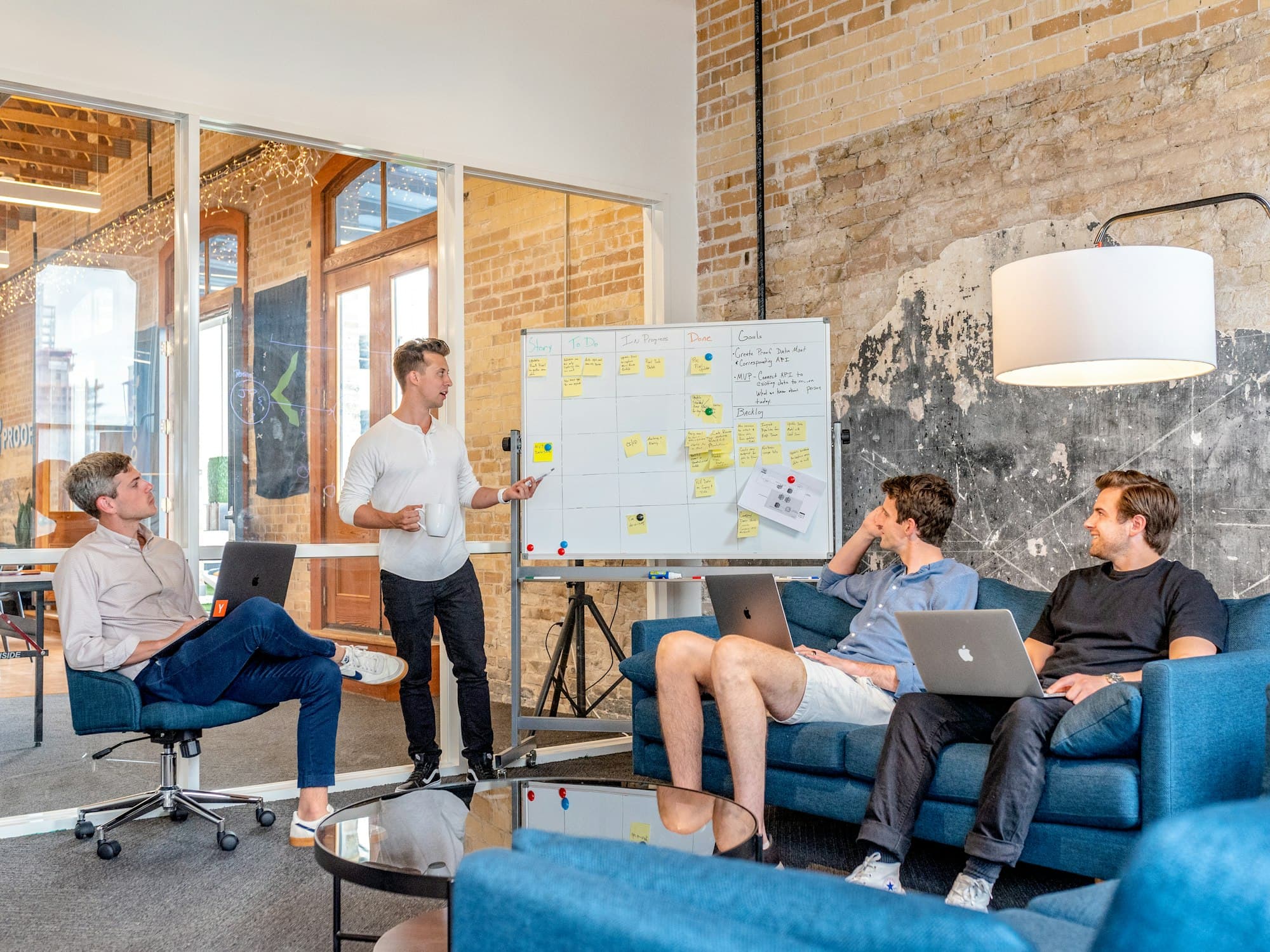 A strategy session with a presenter at a whiteboard and a team on laptops