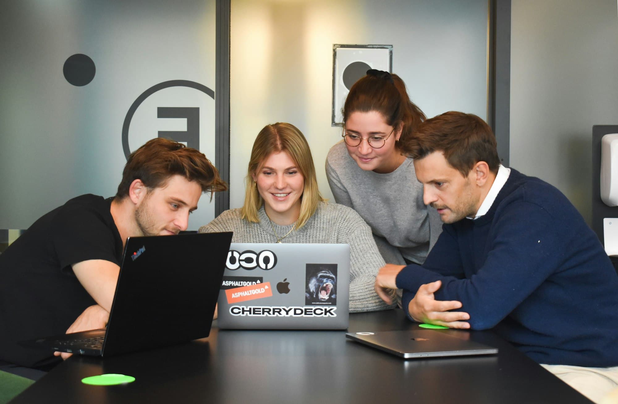 Members of the BootSoc team collaborating around a laptop